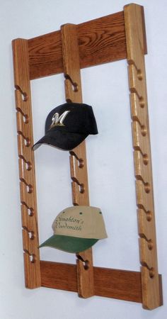 a wooden ladder with hats hanging from it's sides and a baseball cap on top