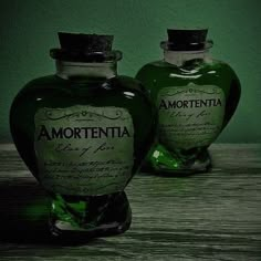 two green bottles sitting on top of a wooden table