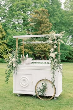 an ice cream cart decorated with flowers and greenery