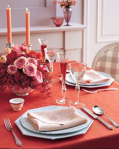 a table set for two with flowers and candles