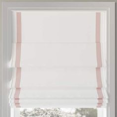 a window with pink and white roman blinds