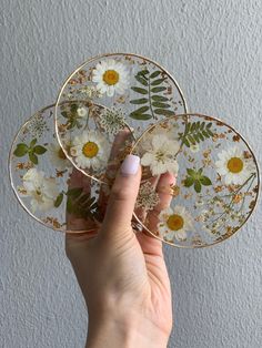 a person holding three plates with flowers on them