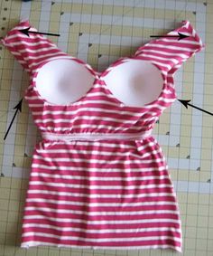 the back of a pink and white striped dress with two large breast pads on it