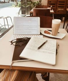 an open laptop computer sitting on top of a table next to a cup of coffee