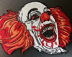 a close up of a patch with a clown's face painted on the side