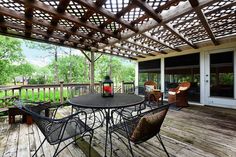 an outdoor deck with chairs and table on it