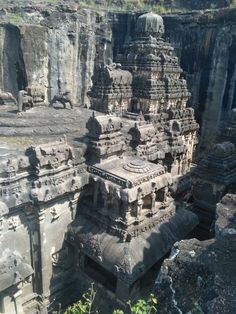 an ancient rock - cut temple in the middle of a cliff with many carvings on it