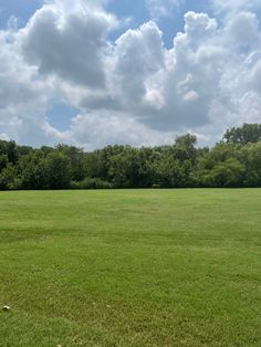 an empty field with trees in the background