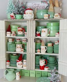 a shelf filled with green dishes and santa clause figurines on top of it