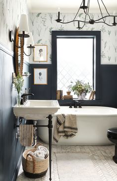 a bath room with a tub a sink and a mirror on the wall next to a window