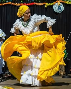 a woman in a yellow dress is dancing