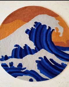 a round rug with an image of a wave in blue and orange colors on it