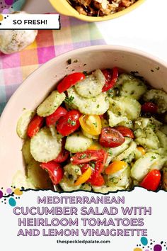 a bowl filled with cucumber salad and topped with tomatoes and lemon vinaigretti