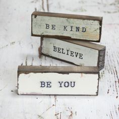 three wooden signs that say be kind, believe and be you on white wood planks