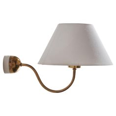 a wall lamp with a white shade on it's side and a gold metal arm