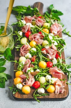 a wooden platter filled with lots of different types of food on top of a table