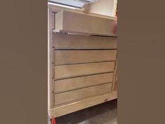 an unfinished dresser is shown in this image, with the bottom drawer open and drawers closed