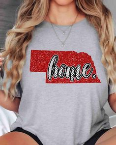 a woman wearing a t - shirt with the word home on it