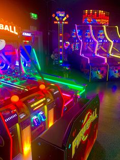 several arcade machines lit up with neon lights