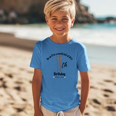 a young boy standing on the beach wearing a blue birthday t - shirt that says born to be wonderful all year