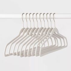 white clothes hangers are hanging on a rail