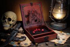 a wooden box with two skulls in it next to a knife and some other items