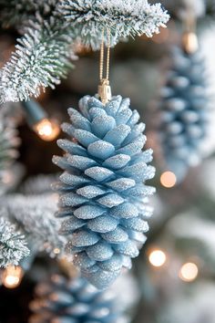 a blue pine cone ornament hanging from a christmas tree