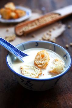 a bowl of yogurt with bread sticks in the background