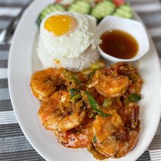 a white plate topped with shrimp and rice