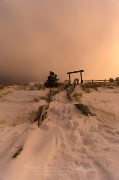 a snow covered field with a bench in the distance