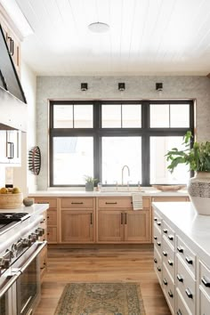 a large kitchen with wooden cabinets and white counter tops, along with an area rug on the floor