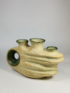 two green vases sitting next to each other on a white tableclothed surface