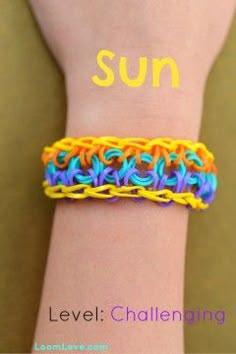 a person wearing a bracelet with the word sun written on it's wrist and an orange, yellow, blue, and green crochet