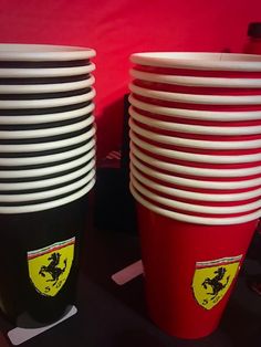 there are many cups stacked on top of each other in this photo, one is black and the other is red