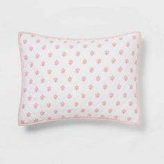 a pink and white pillow with flowers on it