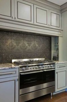 a kitchen with an oven, stove and cabinets in the middle of it's counter space