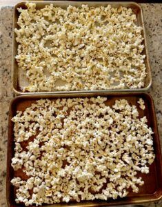 two pans filled with popcorn sitting on top of a counter