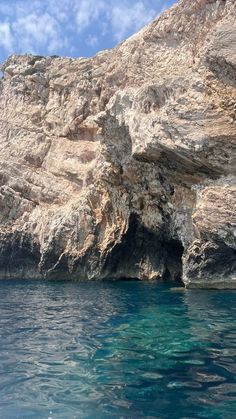 the water is crystal blue and there are rocks on the side of the cliff that surround it