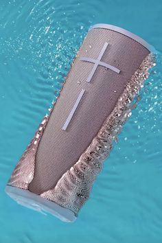 a speaker floating in the water with a cross on it's side and an antenna attached