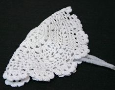 a white crocheted doily on a black background