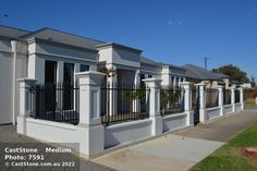 a row of white houses with balconies and black railings