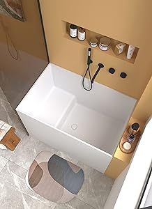 an aerial view of a bathroom with a bathtub, toilet and rugs on the floor