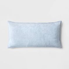 a light blue pillow on a white wall