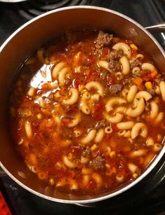 beef and tomato macaroni soup in a large pot on the stove with text overlay