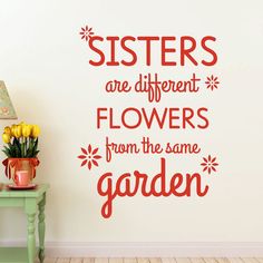 there is a wall sticker that says sisters are different flowers from the same garden