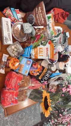 an assortment of food and snacks on a table with sunflowers in the background