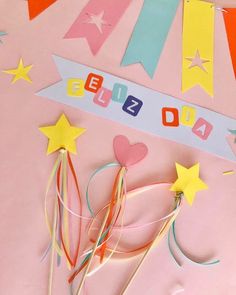 some paper stars and streamers on a pink background