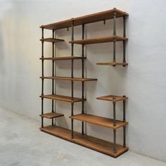 a wooden shelf with metal pipes and shelves on each side, against a white wall