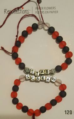 a red and black beaded bracelet with the word stab scream on it's side