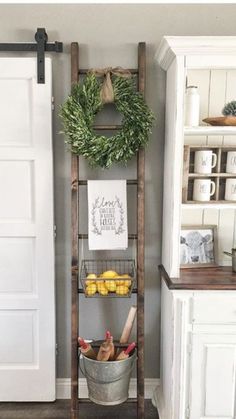 an old wooden ladder is used as a shelf for fruit and vegetables in this kitchen